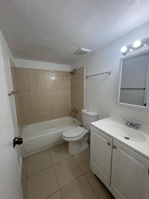 A white bathroom with a toilet, sink, and bathtub.