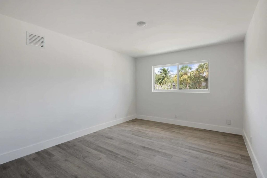 an empty room with white walls and a window