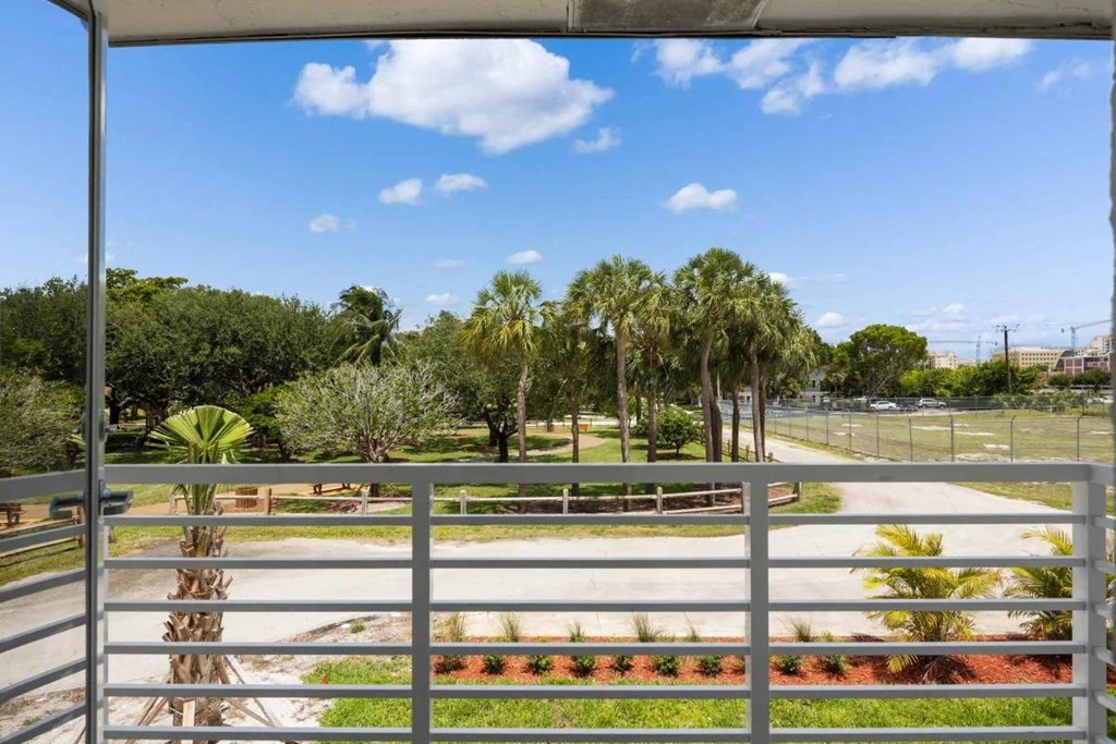 the view from the balcony of a building overlooking a park