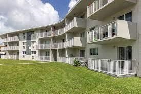 an image of an apartment building with a grassy yard