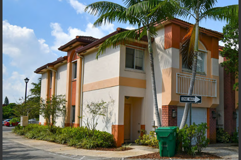 a row of houses with palm trees in front of them