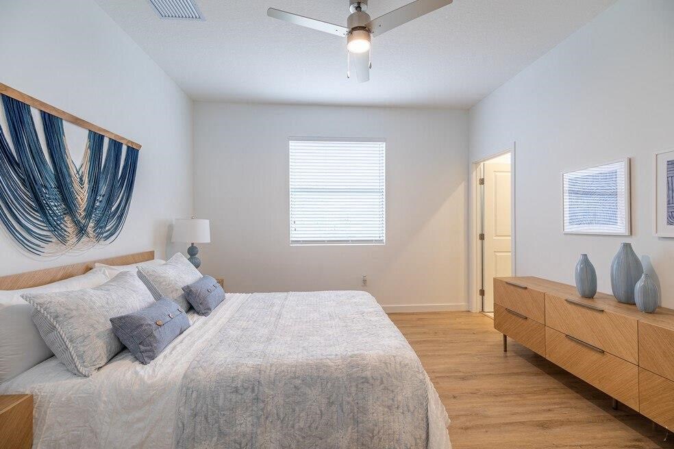 A bedroom with a large bed and a ceiling fan