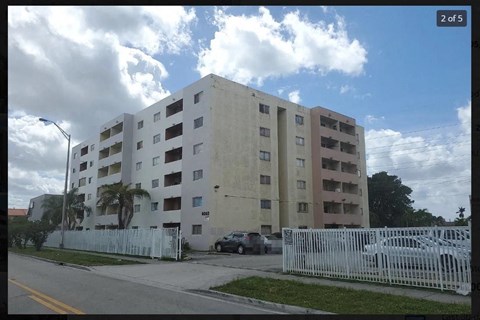 a large white building with cars parked in front of it
