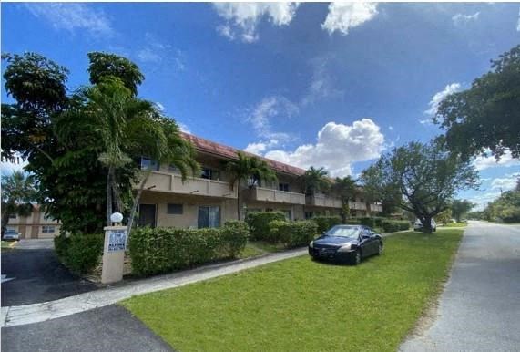 a car parked in the grass outside an apartment building