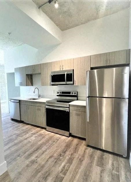 a kitchen with stainless steel appliances and a refrigerator