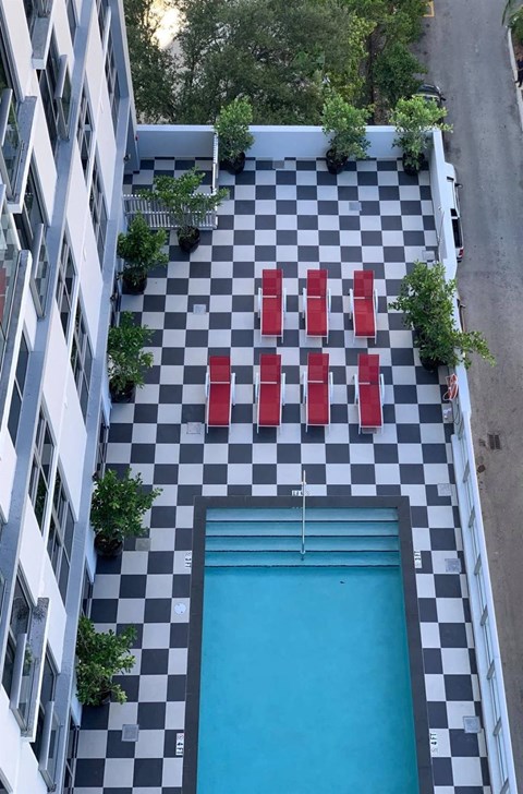 a swimming pool in the middle of a building with red chairs
