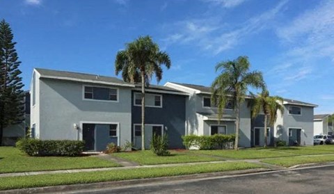 a group of houses with palm trees in front of them