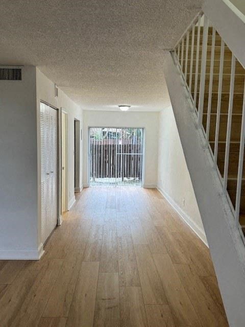 a empty living room with a staircase and wood floors