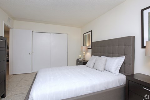 A bedroom with a large bed and a dresser.