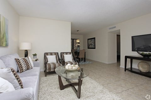 A living room with a couch, chairs, and a coffee table.