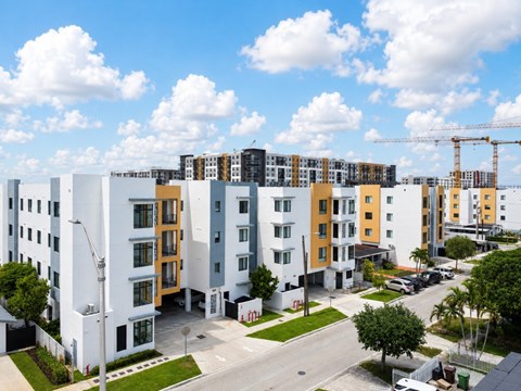 A row of modern apartment buildings with a clear blue sky above.