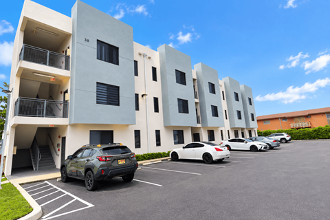 A parking lot with cars and apartment buildings.