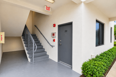 A staircase with a metal railing leads to a door with the number 101 on it.