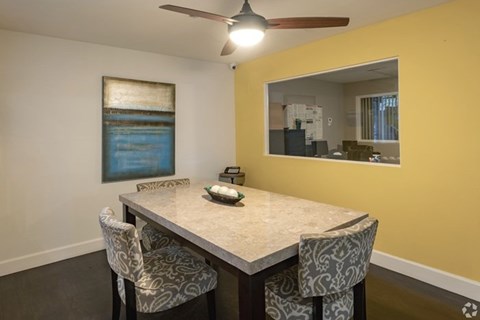 A dining room with a table and chairs.