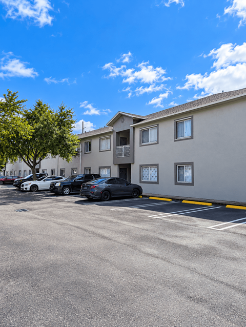A parking lot with cars and a building in the background.