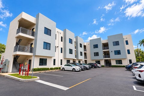 A white building with a parking lot in front of it.