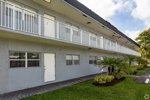 A white building with a balcony and a white door.
