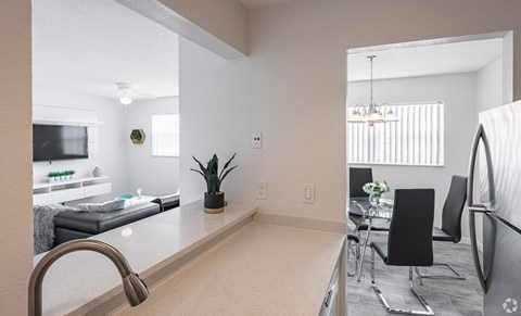 A kitchen with a sink and a dining table.