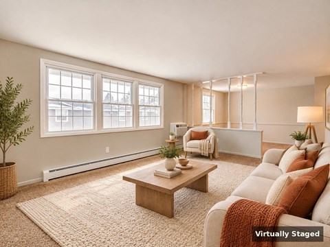 A living room with a couch, coffee table, and large windows.