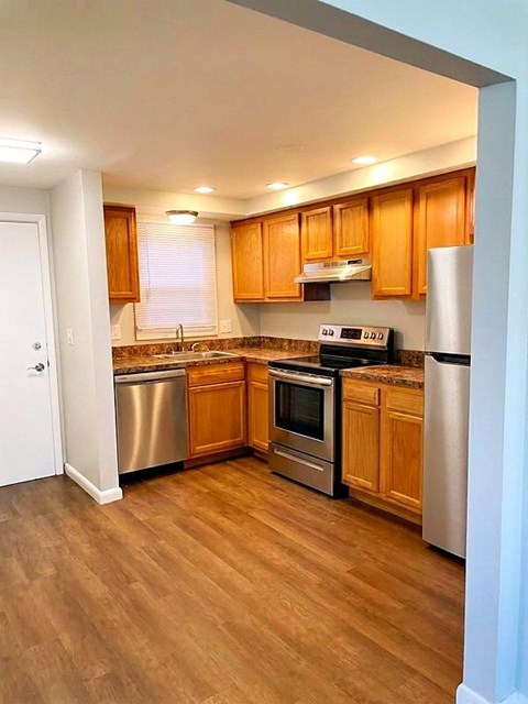 A kitchen with wooden cabinets and stainless steel appliances.