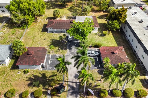 A bird's eye view of a residential area with houses and palm trees.