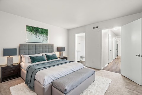 A bedroom with a large bed and a painting on the wall.