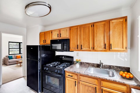A kitchen with wooden cabinets and a black stove top oven.