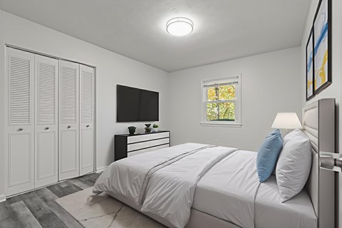 A bedroom with a bed, dresser, and wardrobe.