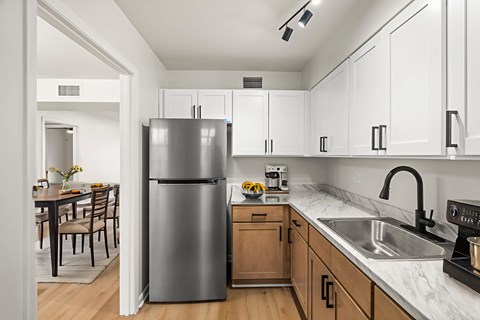 A modern kitchen with a stainless steel refrigerator and wooden cabinets.