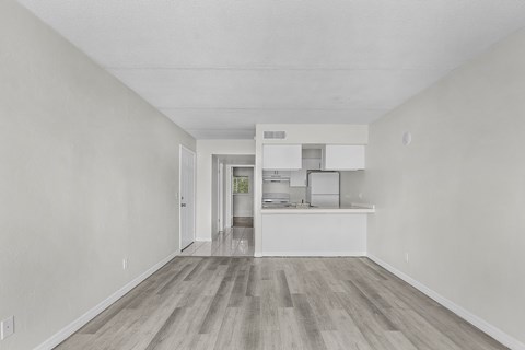 A kitchen with white cabinets and a wooden floor.