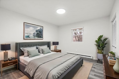 A bedroom with a large bed and a painting on the wall.