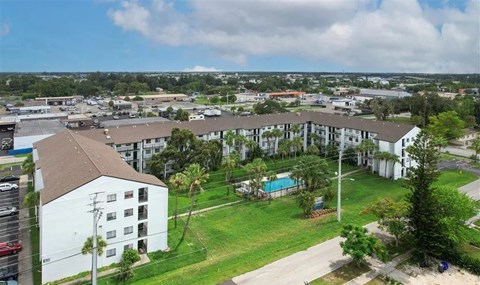 A view of a residential area with apartment buildings and a swimming pool.