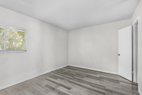 A room with a wooden floor and a window.