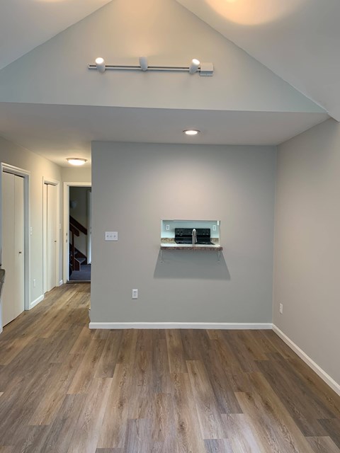 A room with wooden flooring and a shelf with two items on it.