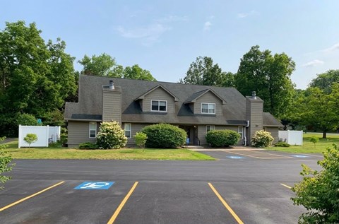 A parking lot in front of a building with a handicap parking space.