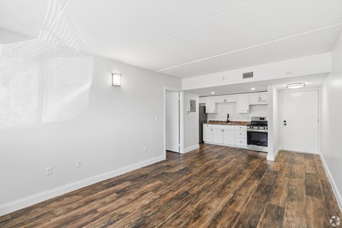 A large empty room with wooden floors and white walls.