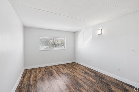 A room with wooden flooring and a window.
