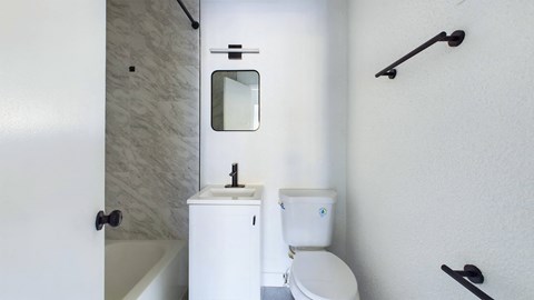 A white toilet with a sink and mirror in a bathroom.