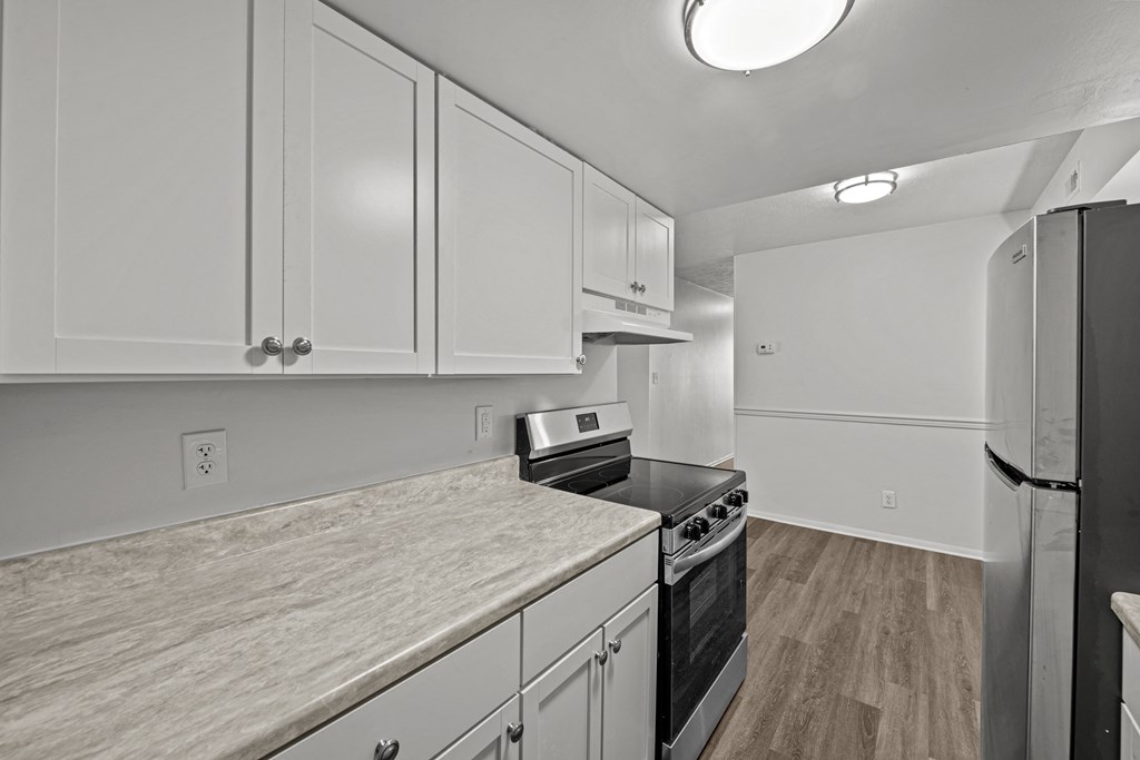 A kitchen with white cabinets and a black stove top oven.