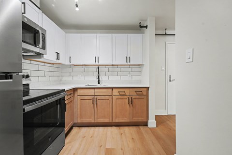 A kitchen with wooden cabinets and a black oven.