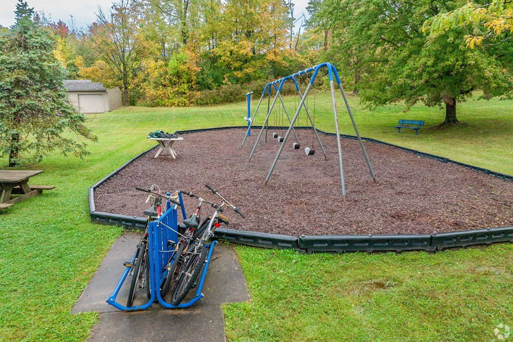 A playground with a blue swing set and a bike rack.