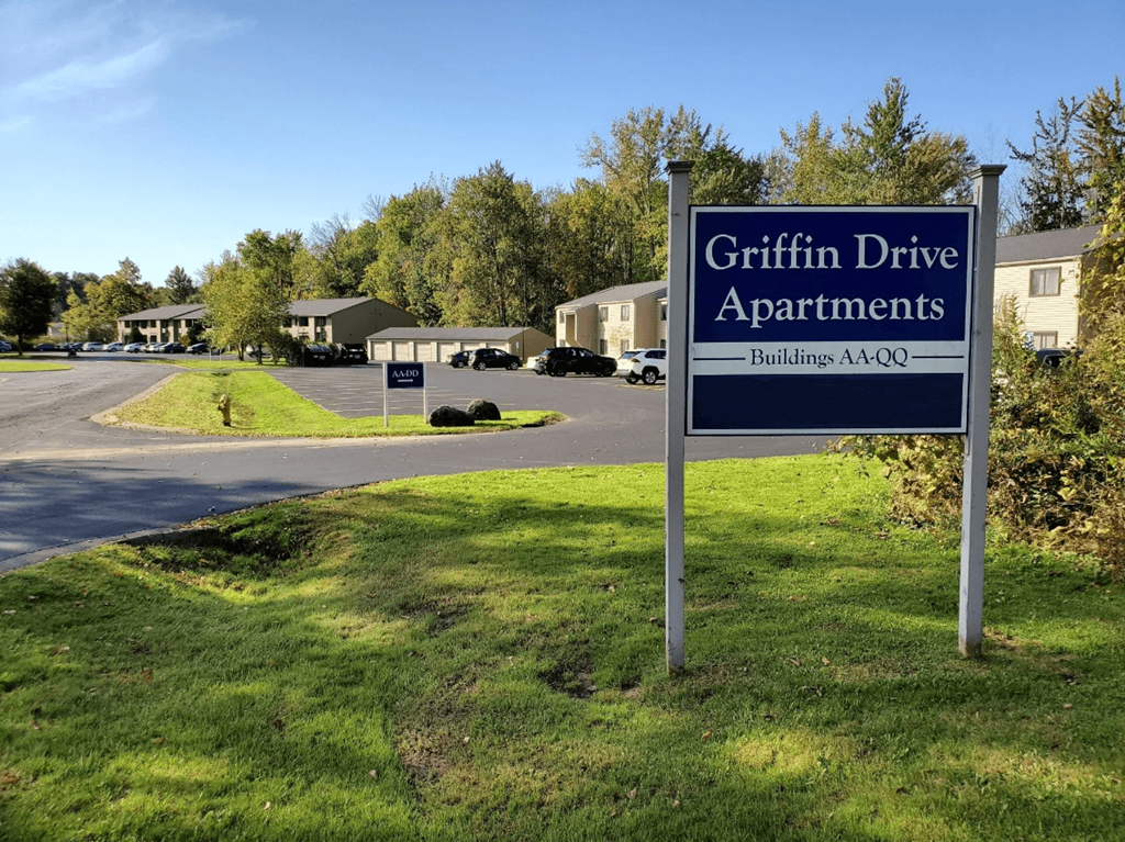 A sign for Griffin Drive Apartments stands in front of a grassy area.