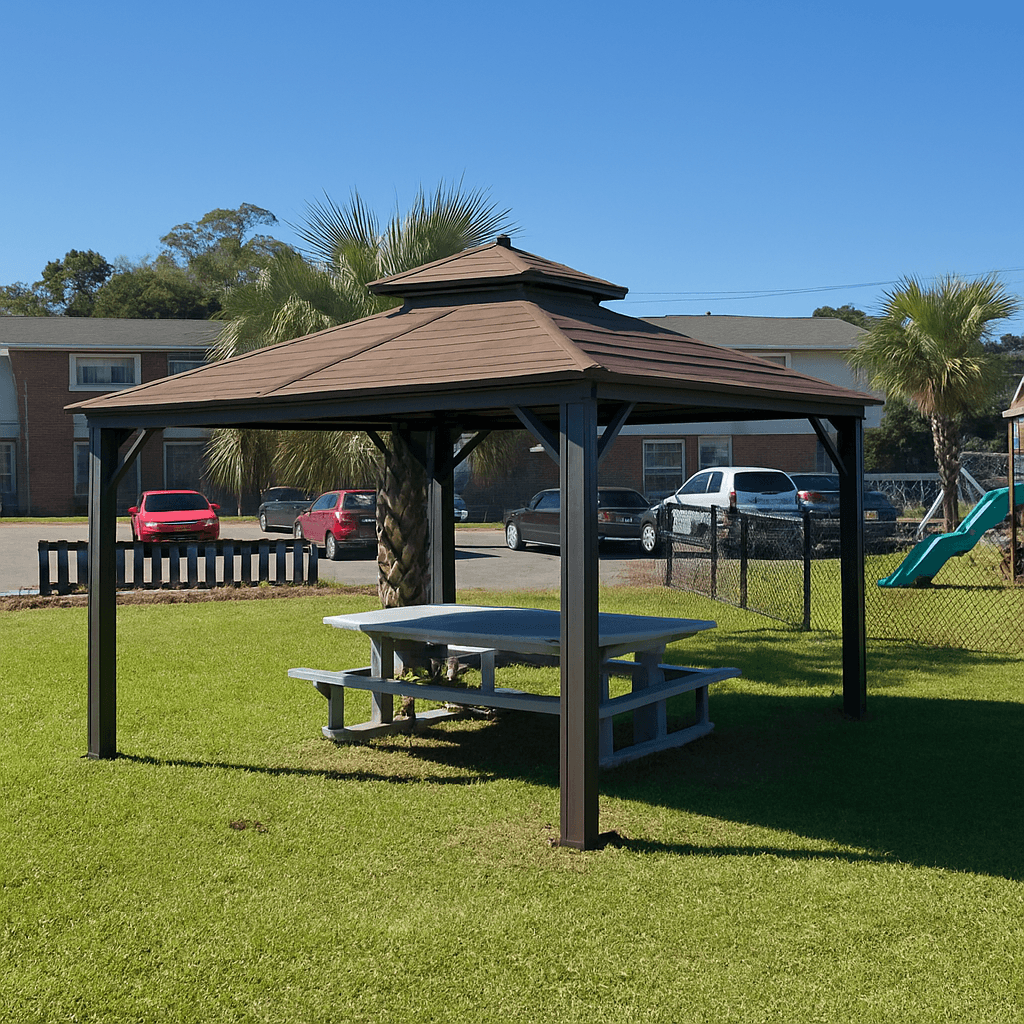 A pavilion with a table is in the middle of a grassy area.