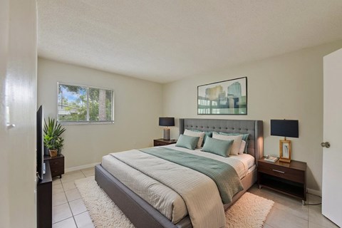A bedroom with a large bed and a flat screen TV.