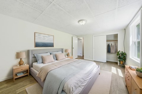 A bedroom with a large bed and a painting on the wall.