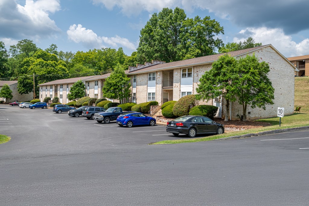 A parking lot with cars and apartment buildings in the background.