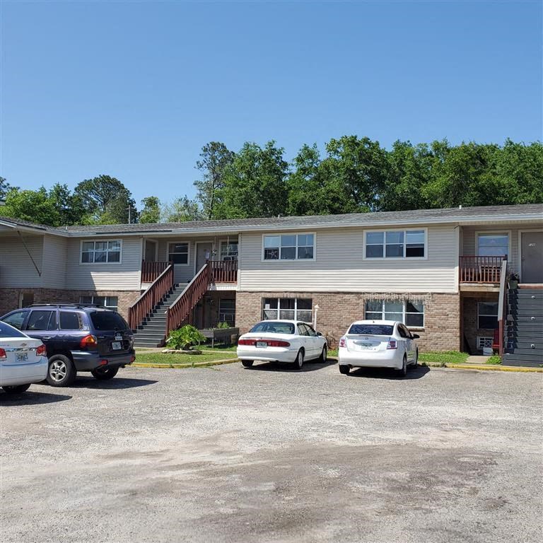A parking lot with cars and a building in the background.