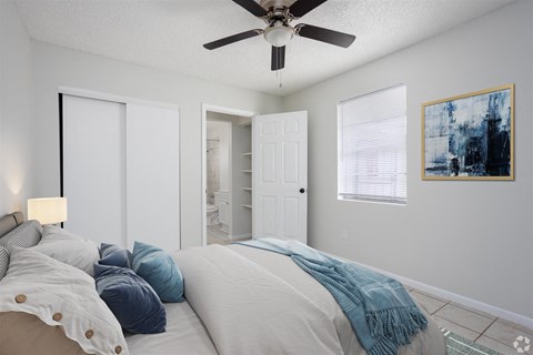 a bedroom with a large bed and a ceiling fan