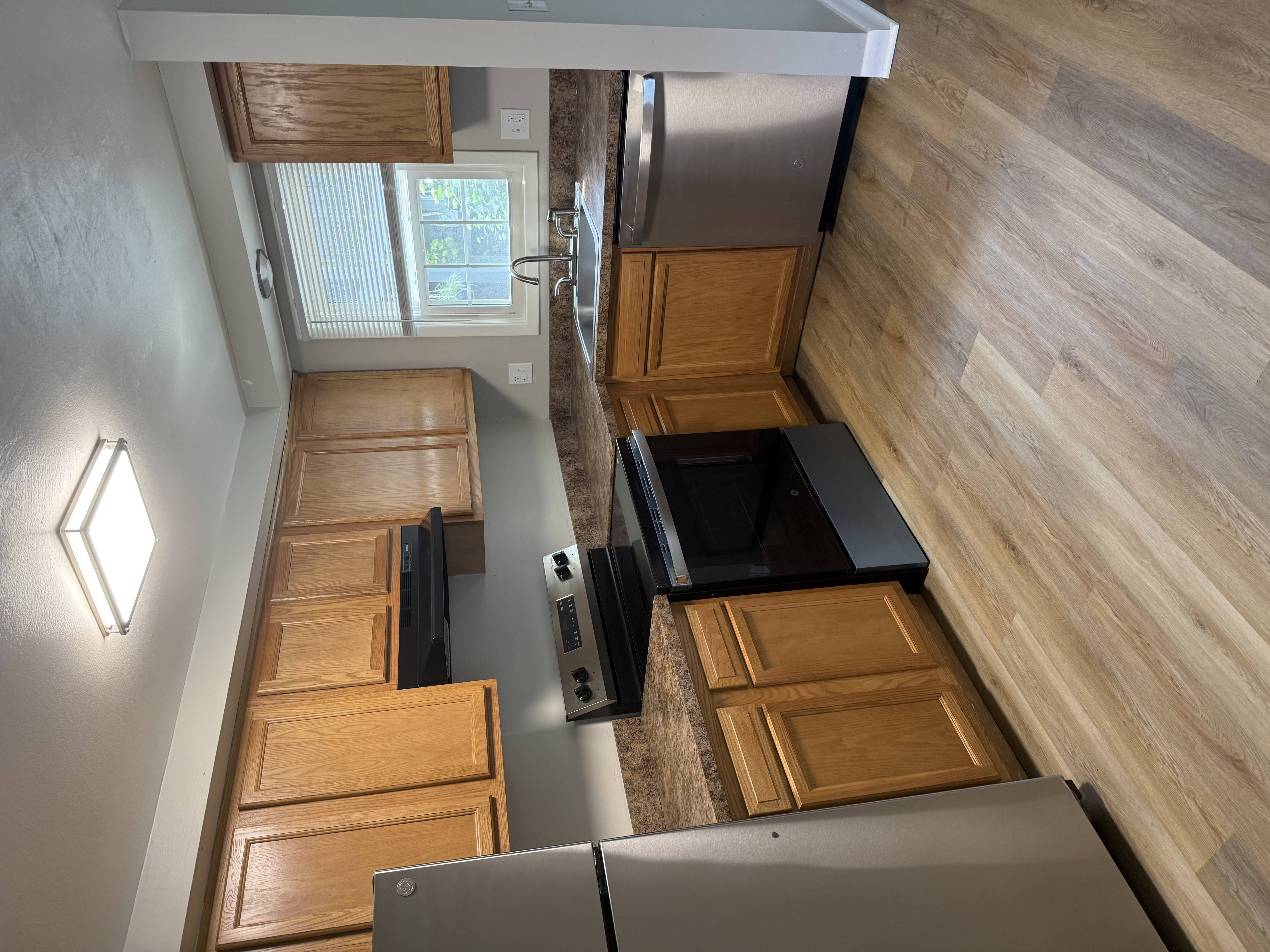 A kitchen with wooden cabinets and a black countertop.