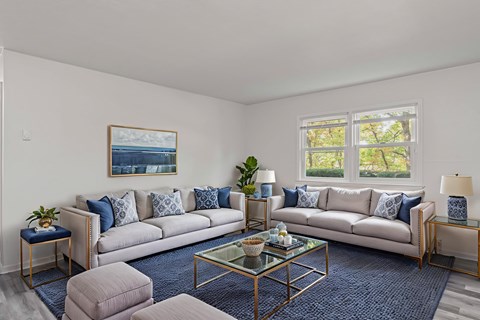 A living room with a large couch, a coffee table, and a painting on the wall.
